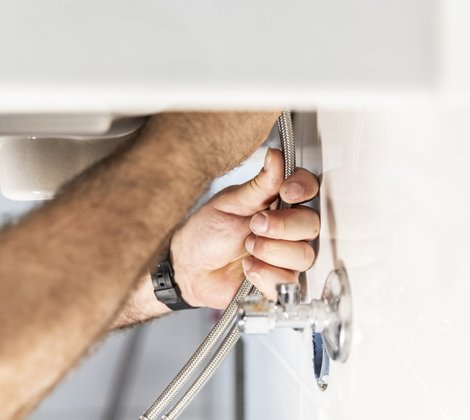 Rieber Mitarbeiter schließt eine Abwasserleitung an einen Siphon an