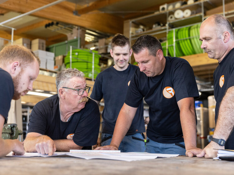 Das Rieber Team bespricht gemeinsam einen Bauplan im Lager