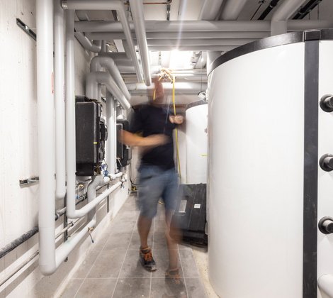 Rieber Mitarbeiter arbeitet im Keller an einer Wärmepumpe