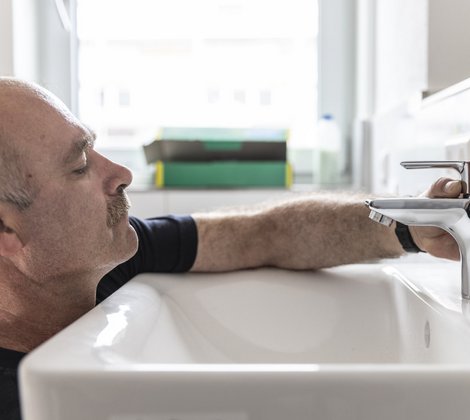 Rieber Mitarbeiter arbeitet im Sanitärbereich in einem Badezimmer